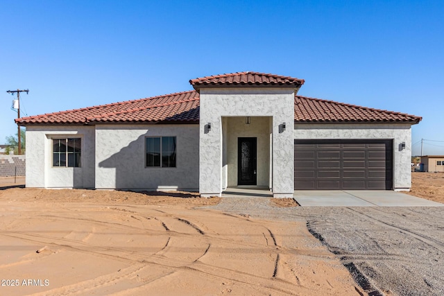 mediterranean / spanish home featuring a garage