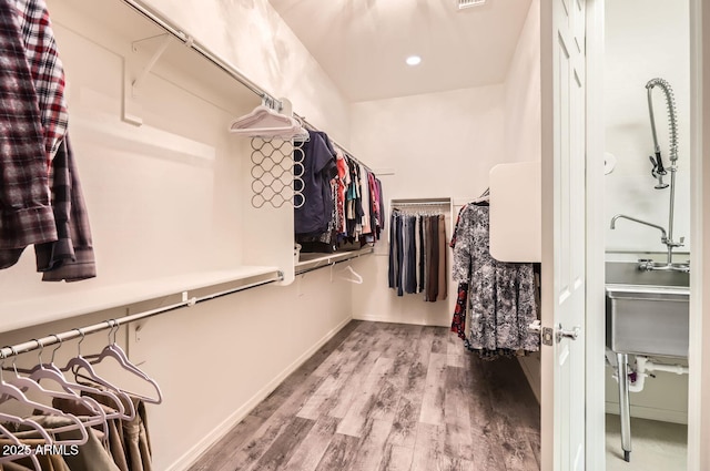 walk in closet with hardwood / wood-style floors