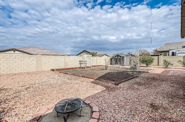 view of yard with a storage unit and an outdoor fire pit