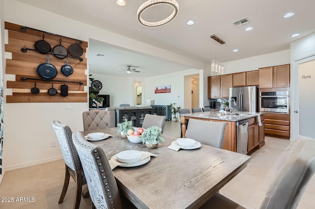 tiled dining area with ceiling fan and sink