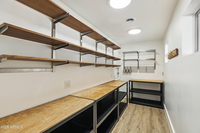 bar featuring baseboards, visible vents, and light wood finished floors