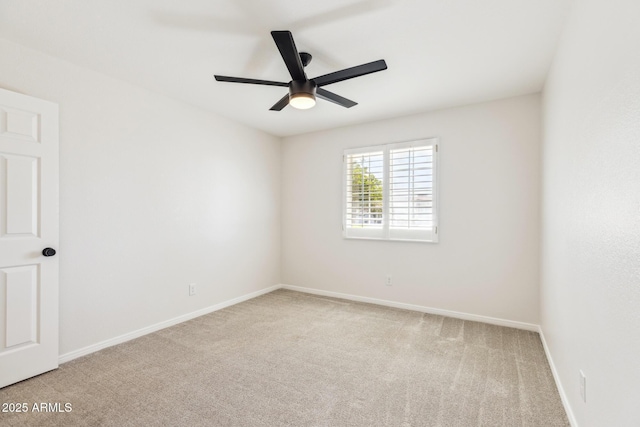 carpeted spare room featuring ceiling fan and baseboards