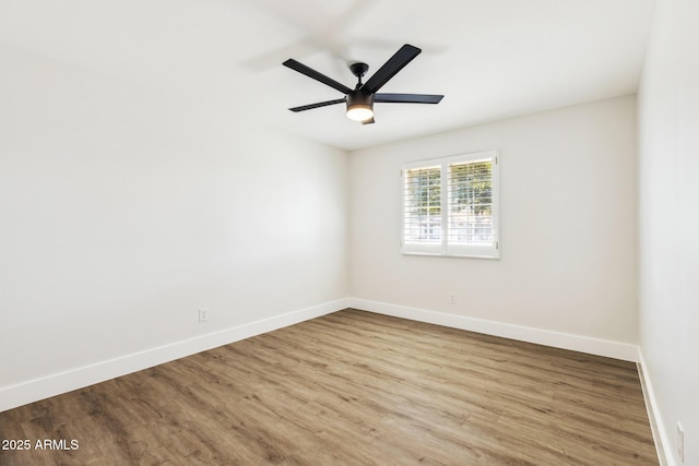 unfurnished room with a ceiling fan, baseboards, and wood finished floors