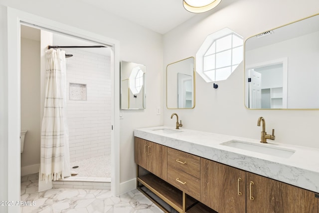 full bath featuring marble finish floor, double vanity, a sink, and a shower stall