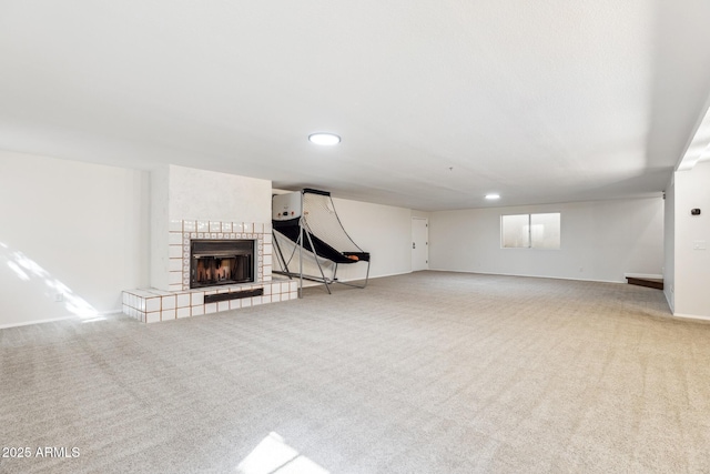 unfurnished living room with light carpet, a fireplace, and baseboards