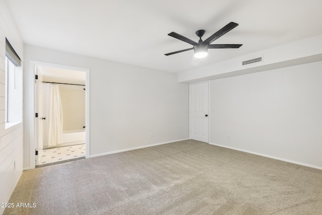 unfurnished bedroom with carpet floors, baseboards, visible vents, and ensuite bathroom