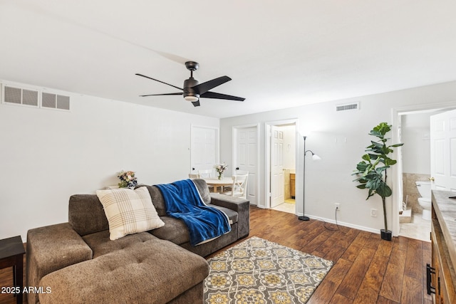 living area with ceiling fan, dark wood-style flooring, visible vents, and baseboards