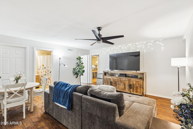 living area with ceiling fan, visible vents, dark wood finished floors, and baseboards