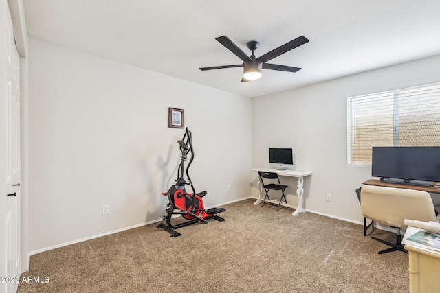 carpeted office with ceiling fan and baseboards