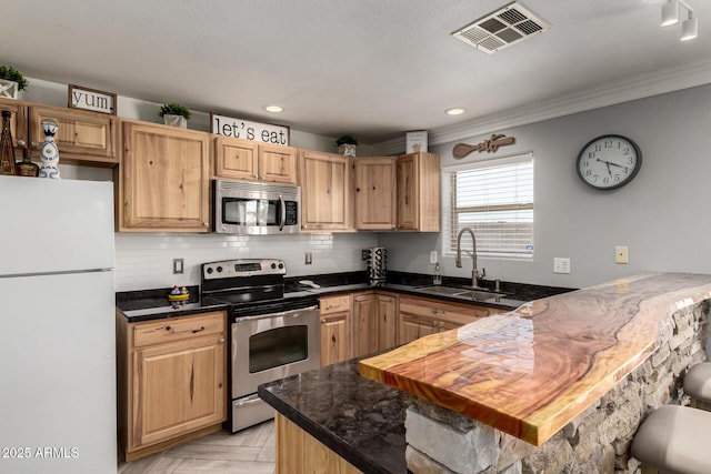 23332 N Serenity Trl, Florence, AZ 85132 - kitchen with stainless steel appliances, a peninsula, crown molding, dark countertops, and decorative backsplash