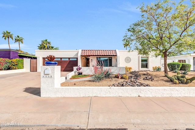 view of front of property featuring a tiled roof, driveway, and stucco siding