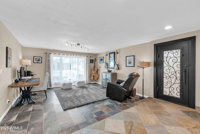 living area with stone finish floor, baseboards, and recessed lighting