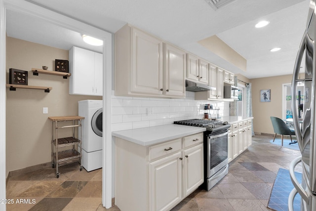 kitchen featuring tasteful backsplash, light countertops, under cabinet range hood, stone tile floors, and stainless steel appliances