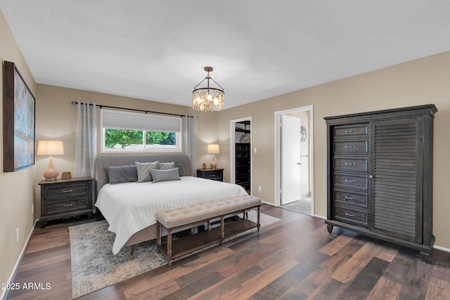 bedroom with a notable chandelier, dark wood-style floors, and baseboards