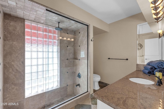 bathroom featuring vanity, a tile shower, and toilet