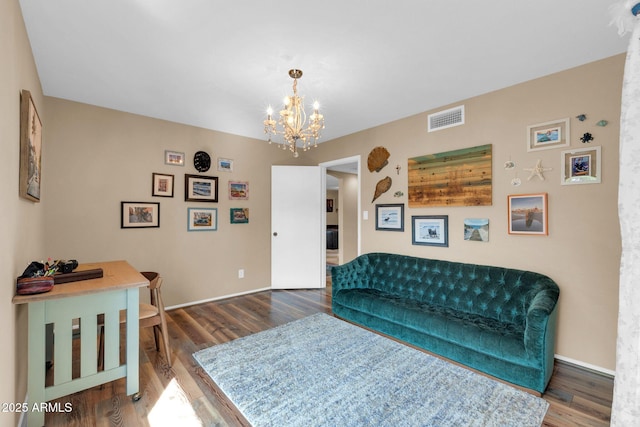 living room featuring a chandelier, visible vents, baseboards, and wood finished floors