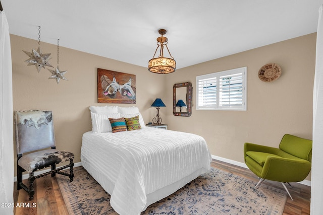 bedroom with baseboards and wood finished floors