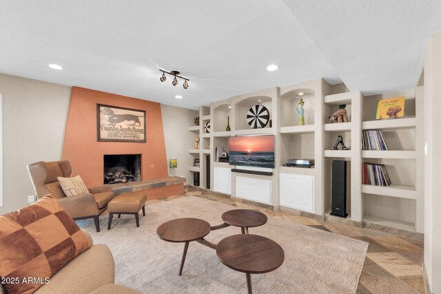 living area with a textured ceiling, a large fireplace, built in shelves, and recessed lighting