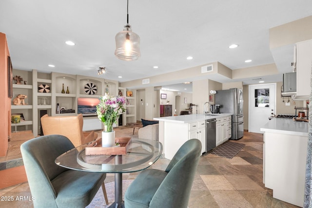 dining room featuring built in shelves, visible vents, and recessed lighting