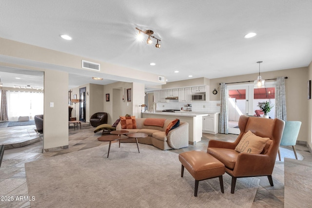 living area with visible vents and recessed lighting