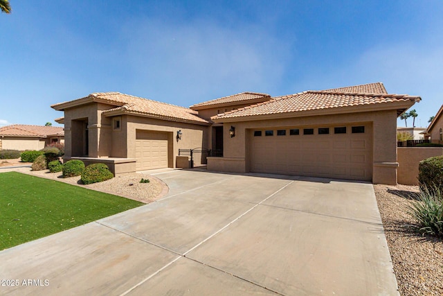 view of front of home with driveway, a tiled roof, an attached garage, and stucco siding