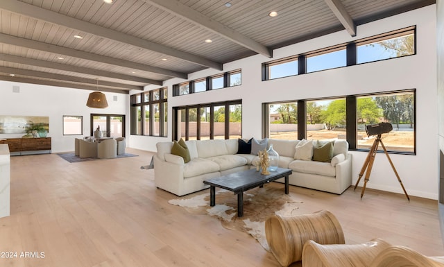 living room featuring french doors, light hardwood / wood-style floors, and a high ceiling