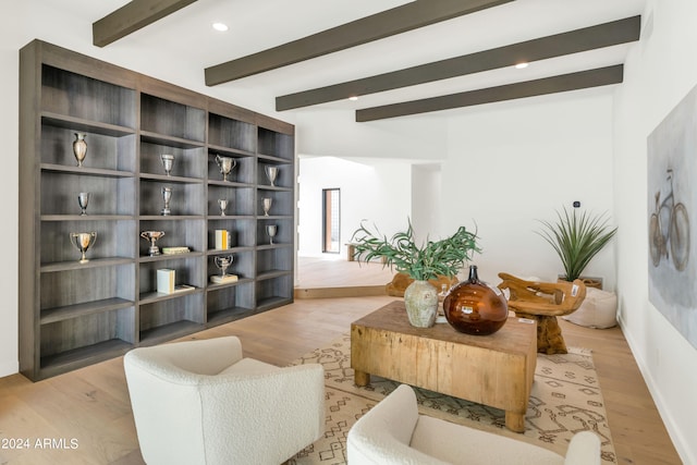 living room featuring beamed ceiling and light hardwood / wood-style flooring