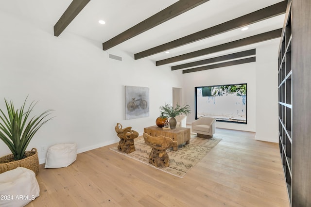 sitting room featuring beamed ceiling and light hardwood / wood-style flooring