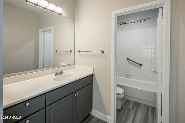 full bathroom with hardwood / wood-style flooring, vanity, toilet, and tiled shower / bath combo