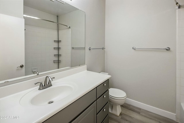 bathroom featuring walk in shower, wood-type flooring, toilet, and vanity