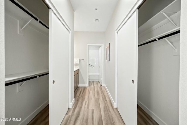 spacious closet with light hardwood / wood-style floors