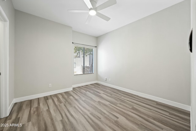 empty room with ceiling fan and light hardwood / wood-style flooring