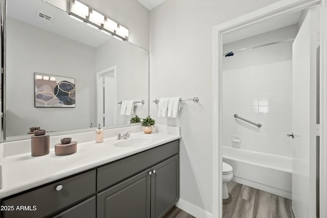 full bathroom featuring shower / bath combination, wood-type flooring, vanity, and toilet