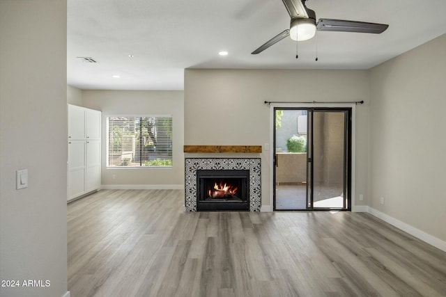 unfurnished living room with a fireplace, light hardwood / wood-style floors, and ceiling fan