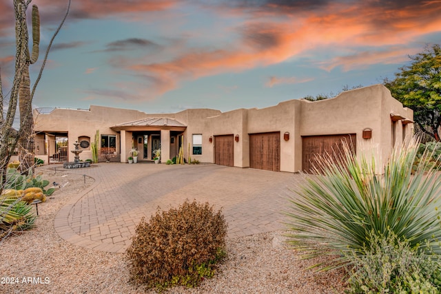 pueblo revival-style home featuring a garage