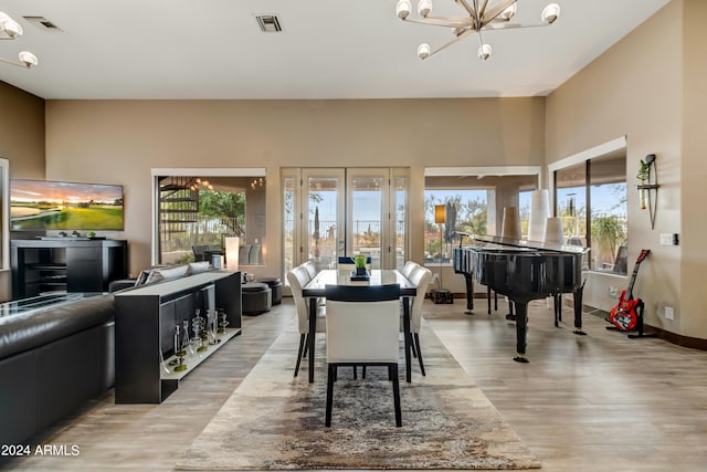 interior space with french doors, an inviting chandelier, and light hardwood / wood-style floors