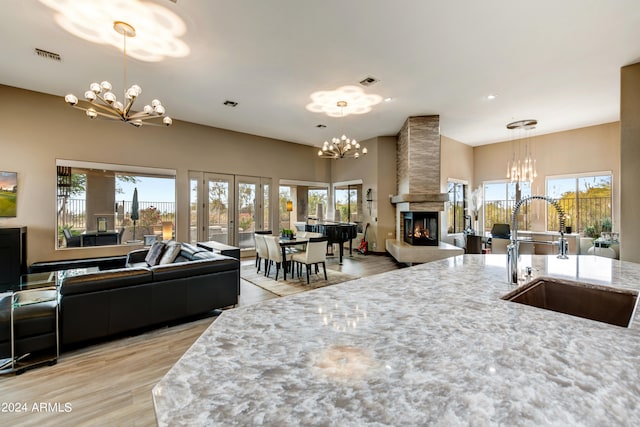 interior space with hanging light fixtures, a fireplace, sink, and a notable chandelier