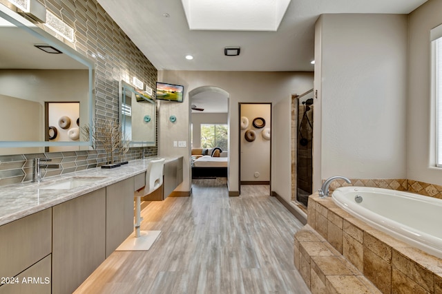 bathroom with hardwood / wood-style flooring, tasteful backsplash, shower with separate bathtub, and vanity