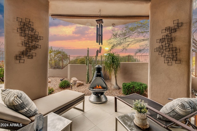 patio terrace at dusk featuring a fire pit