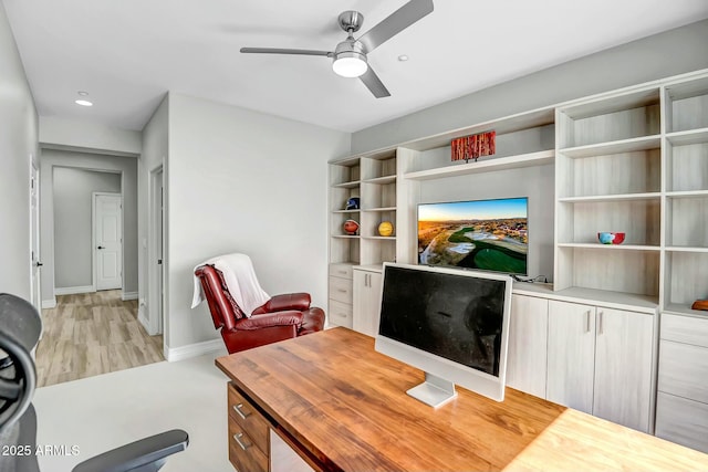 home office with ceiling fan and light hardwood / wood-style flooring