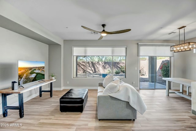 living room featuring ceiling fan and light hardwood / wood-style flooring