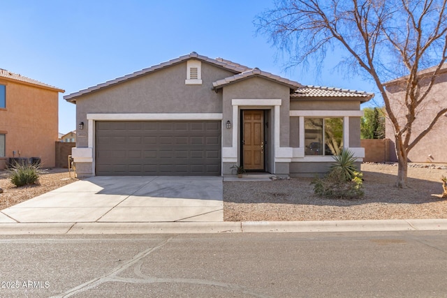 view of front of property featuring driveway, a tiled roof, an attached garage, and stucco siding