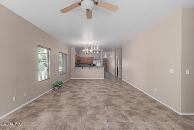 unfurnished living room featuring light tile patterned floors, ceiling fan with notable chandelier, and baseboards