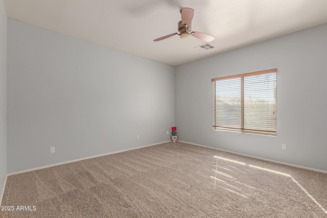 carpeted empty room with ceiling fan, visible vents, and baseboards