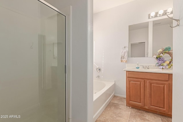 bathroom featuring a stall shower, tile patterned flooring, a garden tub, and vanity