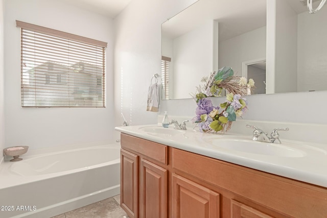 full bath featuring double vanity, tile patterned flooring, a sink, and a bath