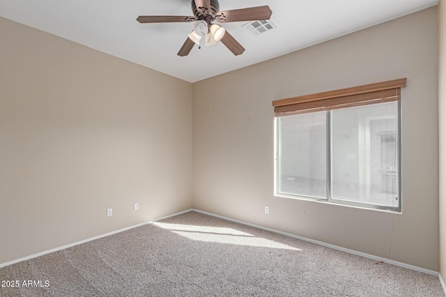 empty room featuring carpet floors, visible vents, ceiling fan, and baseboards