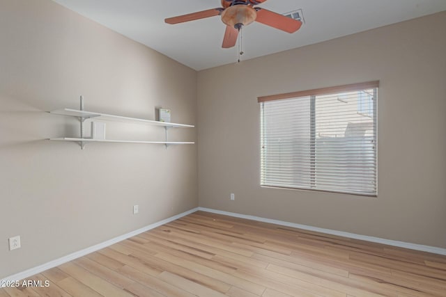 spare room featuring light wood-style flooring, baseboards, and ceiling fan