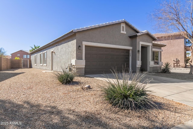 single story home with an attached garage, fence, concrete driveway, a tiled roof, and stucco siding