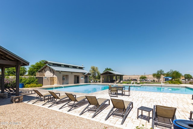 community pool with a patio area and fence